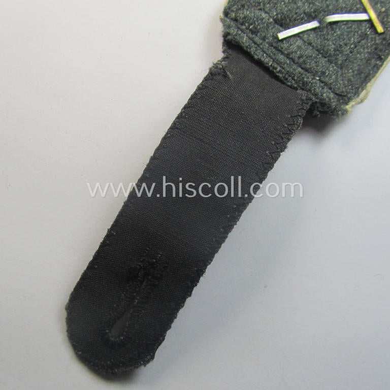 Single, Waffen-SS NCO-type and neatly 'cyphered' shoulderstrap as piped in the white-coloured branchcolour as was intended for usage by an: 'SS-Oberscharführer' who served within the: SS-Rgt. 'Deutschland' (2. SS-Pz-Div. "Das Reich")