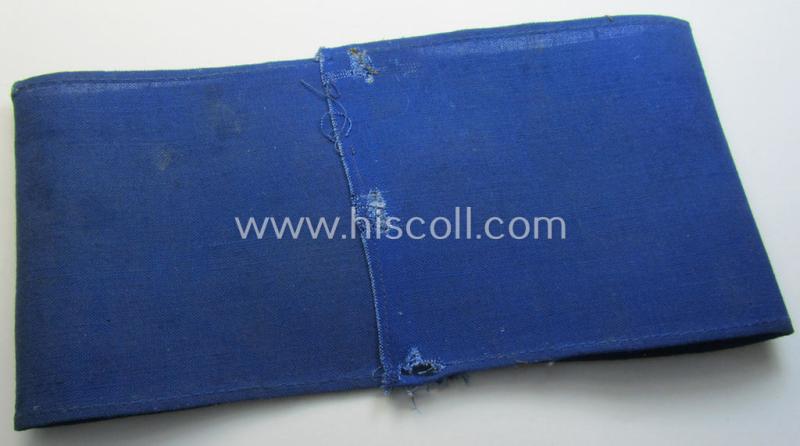 Neat, linnen-based- and/or blue-coloured armband (ie. 'Armbinde') depicting a felt-woolen-based, capital 'M'-character as was presumably intended for staff-members (ie. 'Melder') of the German RLB (ie. 'Reichsluftschutz-Bund')