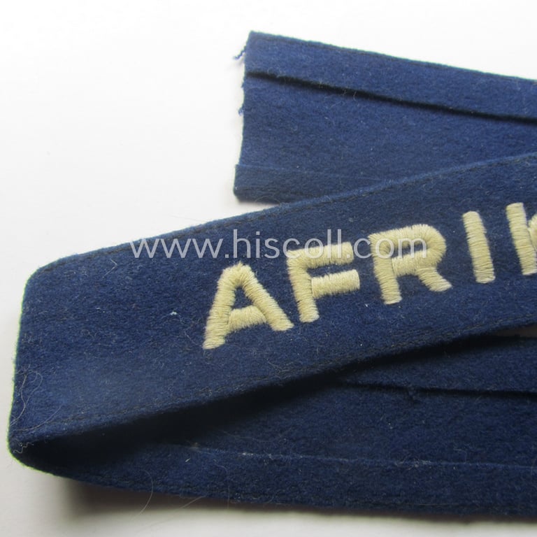 Darker-blue toned, WH (Luftwaffe) cuff-title (ie. 'Ärmelstreifen') entitled: 'Afrika' (being a full-length example that comes in an issued-, used and/or carefully tunic-removed, condition)