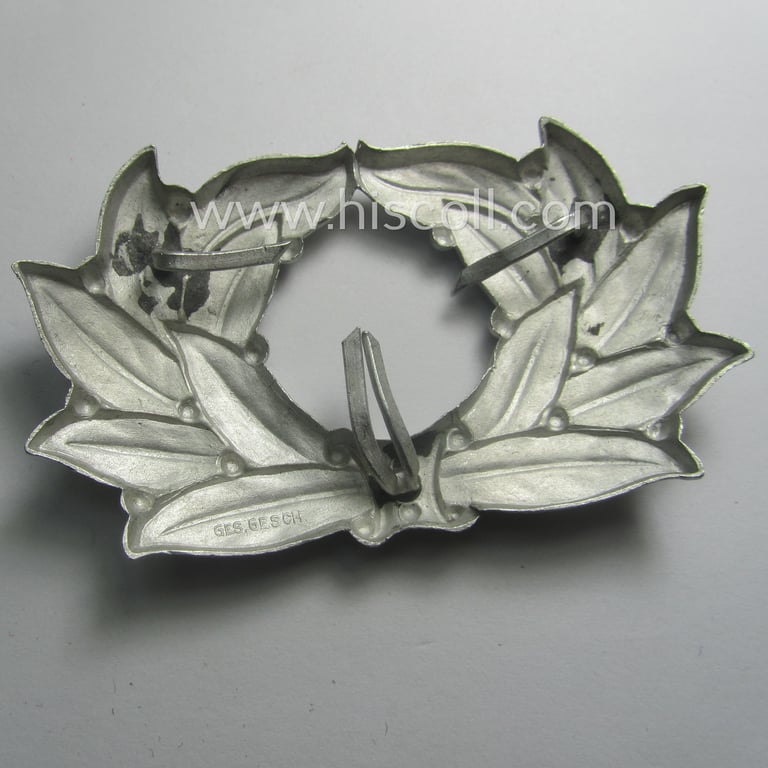 TeNo (ie. 'Technische Nothilfe') officers'-pattern visor-cap cocarde (ie. 'Schirmmützenkokarde für Offiziere der TeNo') being a (non-maker-marked!) example as executed in silver-toned, aluminum-based metal
