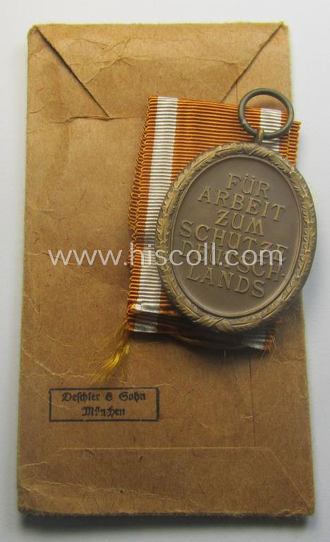 Medal-set: 'Deutsches Schutzwall Ehrenzeichen' (aka: 'Westwall'-medal) being a non-maker-marked- and/or: typical 'Buntmetall'-based specimen that comes packed in its original pouch of issue by the: 'Deschler & Sohn'-company