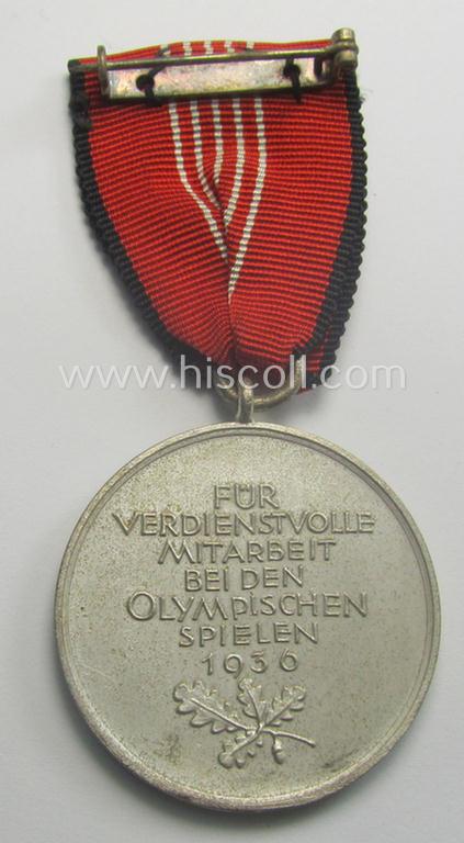 'Deutsche Olympia-Erinnerungsmedaille 1936' being a non-maker-marked example that comes mounted onto its original ribbon (ie. 'Bandabschnitt') and that comes stored in its typical, beige-white-coloured etui
