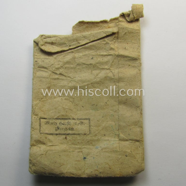 Unusual, silver-class wound-badge (or: 'Verwundeten-Abzeichen in Siber') being a maker- (ie. '127'-) marked example that comes stored in its original (damaged), carton-based pouch by the maker (ie. 'Hersteller'): 'Moriz Hausch A.-G.'