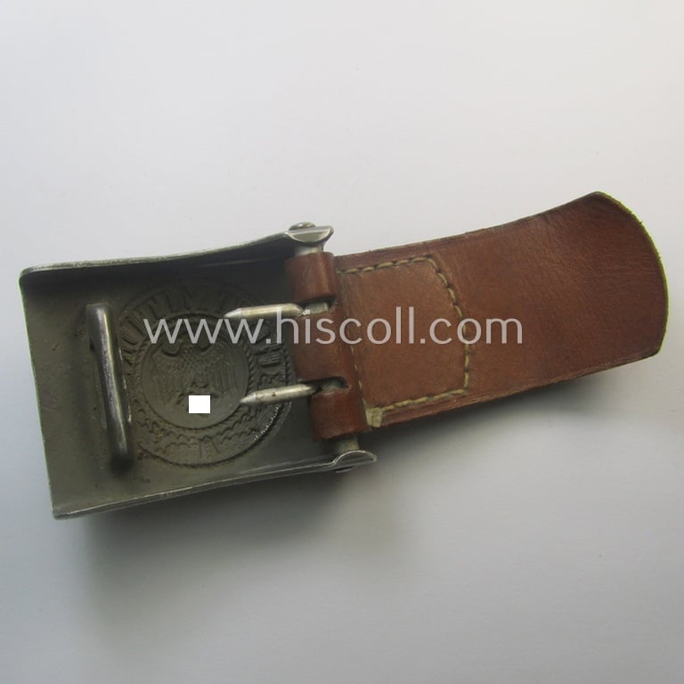 WH (Heeres) 'standard-pattern', field-grey-toned- and aluminium-based belt-buckle being a maker- (ie. 'E. Schneider - Lüdenscheid'-) marked- and/or: '1938'-dated example that comes mounted onto its leather-based tab