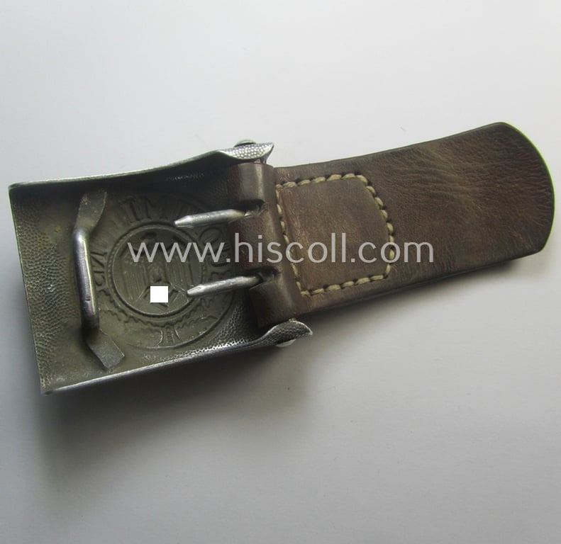 Moderately used WH (Heeres) 'standard-pattern', silver-toned- and aluminium-based belt-buckle being a maker- (ie. 'St.Merkl - Nürnberg'-) marked- and/or: '1938'-dated example that comes mounted onto its leather-based tab