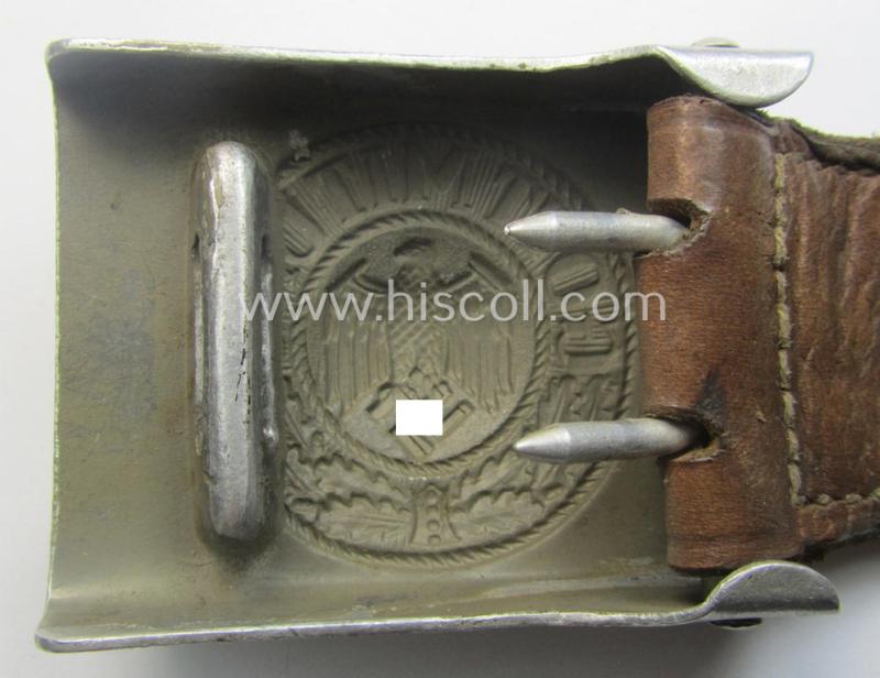 WH (Heeres) 'standard-pattern', field-grey-toned- and aluminium-based belt-buckle being a maker- (ie. 'H. Arld - Nuernberg'-) marked- and/or: '1937'-dated example that comes mounted onto its leather-based tab