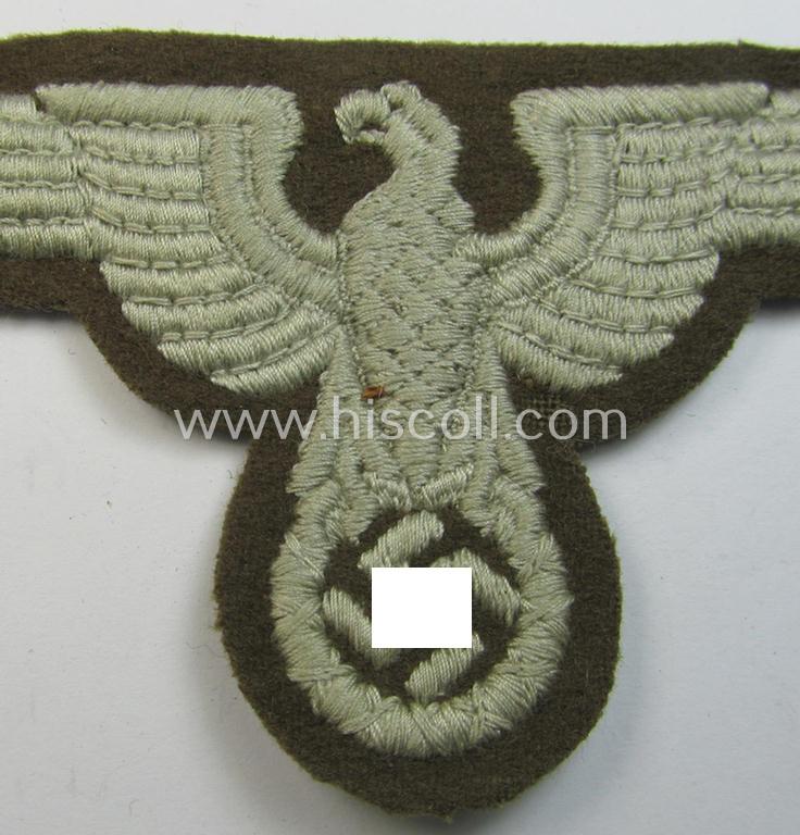 Attractive, machine-embroidered arm-eagle (ie. 'Ärmeladler') as was specifically intended for usage on the brownish-green-coloured tunics of officials of the: 'Reichsministerium für besetzte Ostgebiete' (ie. 'R.M.b.O.')
