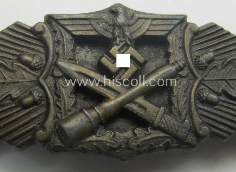 'Nahkampfspange in Bronze' (or: bronze-class close-combat clasp ie. CCC) being a neatly maker-marked- and/or minimally converse-shaped specimen as was produced by the: 'JFS'- (ie. 'Joseph Feix u. Söhne'-) company