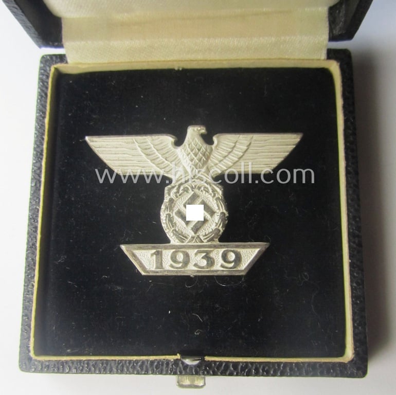 'Wiederholungsspange zum EK I. Klasse' (or: bar to the WWI IC first-class) by the maker (ie. 'Hersteller'): 'B.H. Mayer's Kunstprägeanstalt' and that comes stored in its accompanying etui