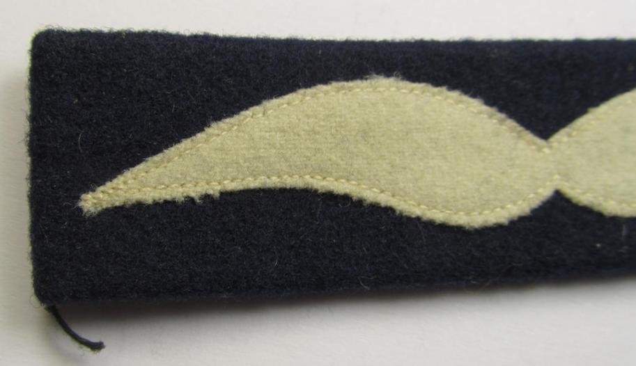 Single, WH (Luftwaffe) beige-coloured- and/or woolen-based, NCO-type rank-patch (aka 'moustache'), as was intended for usage by a non-commissioned officer with the rank of: 'Unteroffizier'