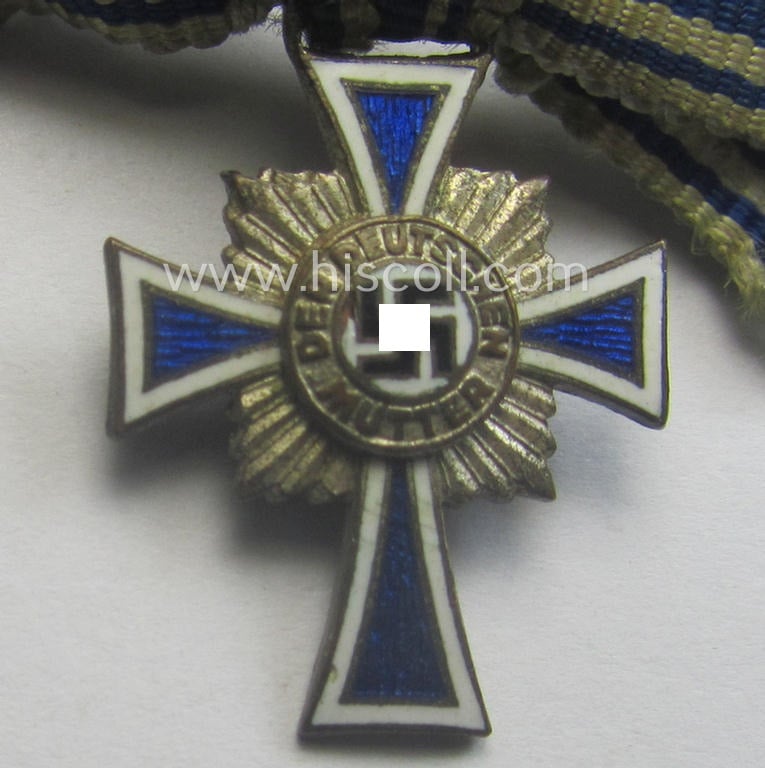 Miniature of an: 'Ehrenkreuz der deutschen Mutter - zweite Stufe' (or: silver-class mothers'-cross) being a non-maker-marked example that comes in an overall nice- (albeit moderately worn- ie. used-), condition