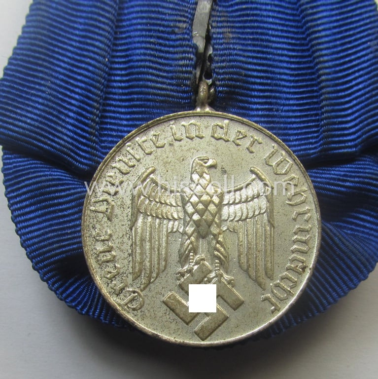 Bright-silver-toned WH (Heeres o. KM) so-called: 'Einzelspange' showing a: 'WH-Dienstauszeichnung 4. Stufe' (as was intended for 4 years of loyal-service) and that shows a detailed, Heeres o. KM-type-eagle-device, period-attached