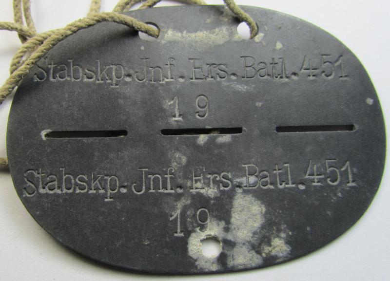 Zinc-based, WH (Heeres) 'Infanterie'- (ie. infantry-) related ID-disc, bearing the clearly stamped unit-designation that simply reads: 'Stabskp. Inf.Ers.Batl. 451' and that comes mounted on its period cord