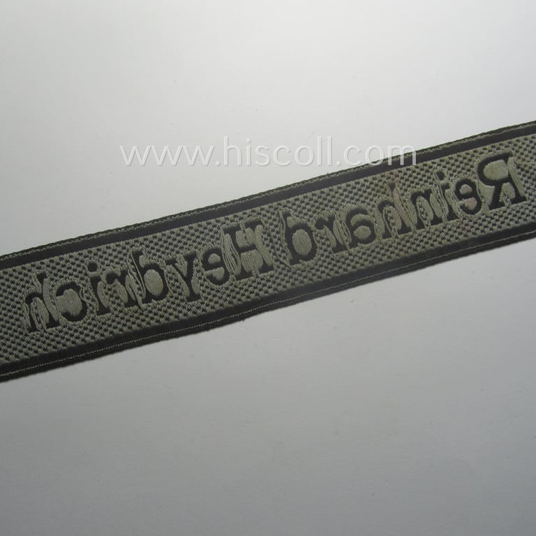 Waffen-SS, 1943-pattern cuff-title (ie. 'Ärmelstreifen') depicting the machine-woven Latin script text in silver-grey linnen as was intended for a member of the: 'SS-Geb.Jäg.-Rgts. 6. (u.11.)': "Reinhard Heydrich"