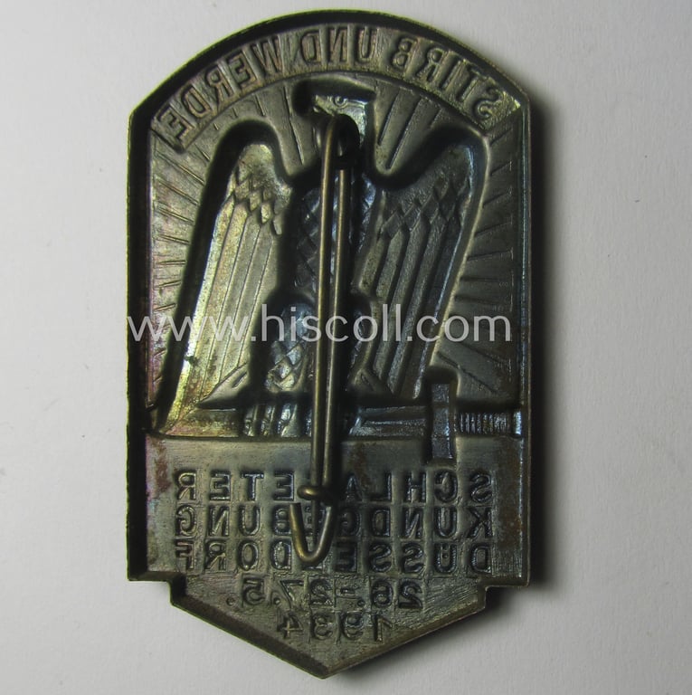 Commemorative, tin-based- and/or: golden-bronze-coloured (I deem) N.S.D.A.P.-related 'tinnie' depicting an eagle-device resting on a sword and that is entitled: 'Stirb und Werde - Schlageterkundgebung - Düsseldorf - 26.27.5.1934'