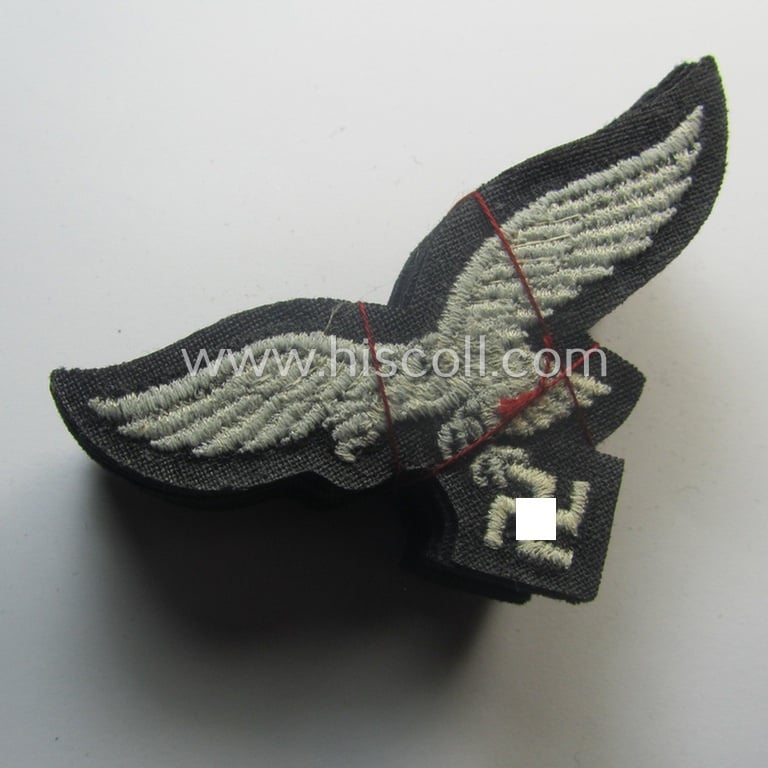 WH (Luftwaffe) cap-eagle (being a 'standard-issue'-pattern example that is executed onto a black-coloured background and that was as such intended for usage on the black-coloured work- ie. 'HG'-related side-caps ie. 'Schiffchen')