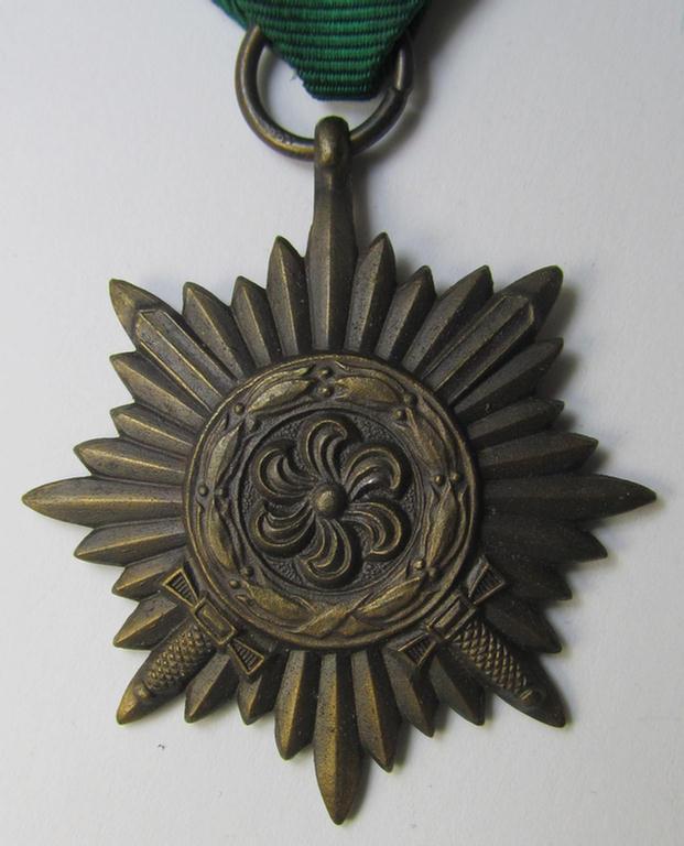 WH-related so-called: 'Tapferkeitsauszeichnung für Angehörige der Ostvölker, 3. Klasse in Bronze mit Schwerter' (being a non-maker-marked- and/or: 'Feinzink'-based example that comes mounted onto its period ribbon)