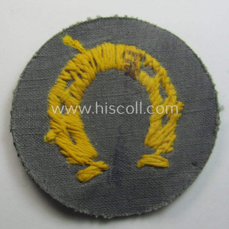 WH (Heeres) so-called: trade- and/or special-career arm-insignia (ie. 'Laufbahn- o. Tätigkeitsabzeichen') as was specifically intended for an army: 'Hufbeschlagmeister' (or: farrier) being a hand-embroidered variant on darker-green-coloured wool