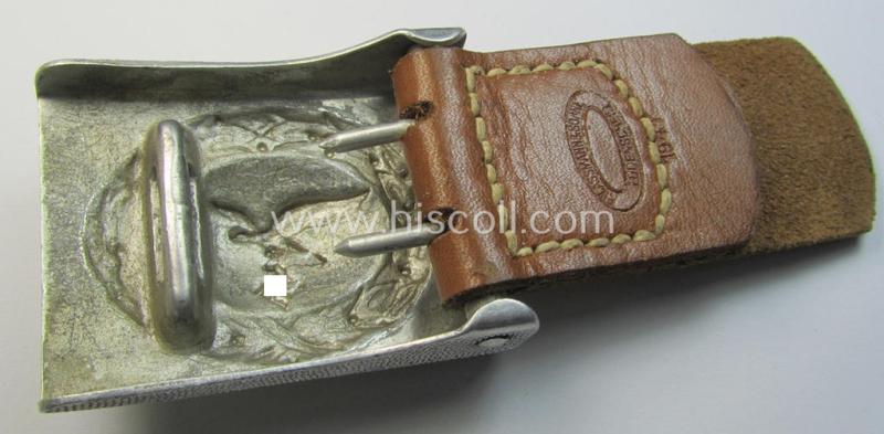 Attractive, WH (Luftwaffe) silver-coloured and aluminium-based belt-buckle, being a maker- (ie. 'F.W. Assmann & Söhne'-) marked example that comes mounted onto its leather-based tab and that comes in a minimally used condition