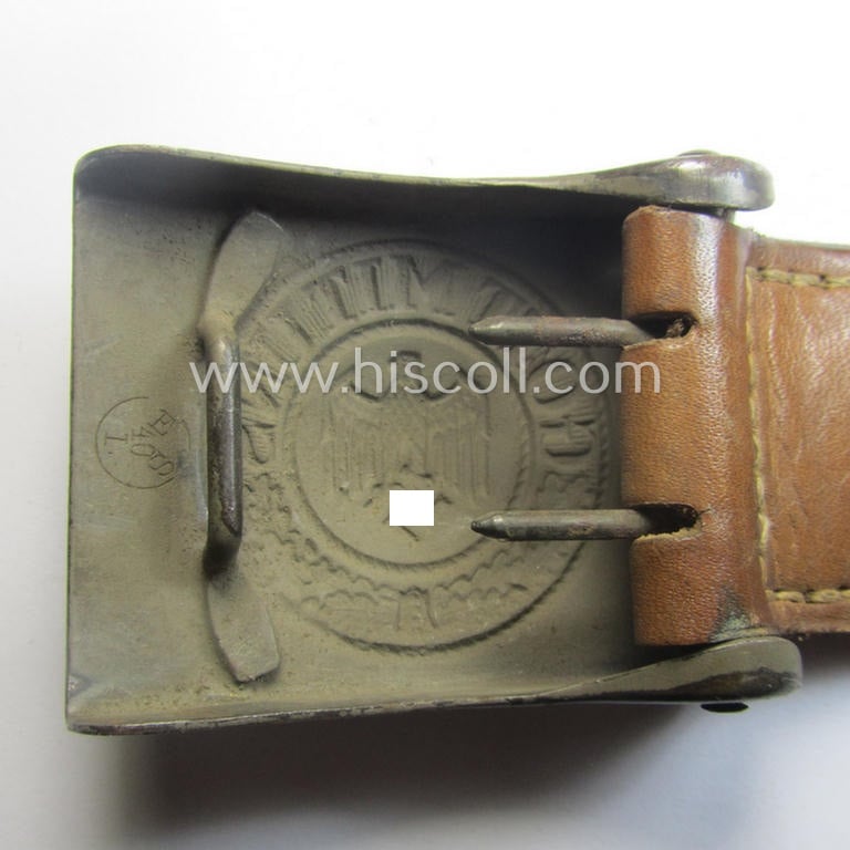 Minimally used, WH (Heeres) field-grey-coloured- and/or steel-based belt-buckle being a clearly maker-marked example that comes mounted onto its maker- (ie. 'E. Schneider - Lüdenscheid'-) marked and/or '1940'-dated leather-based tab