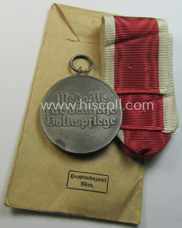 Attractive medal-set: 'Medaille für Deutsche Volkspflege' being a typical non-maker-maker-marked specimen that comes packed in its original pouch of issue by the: 'Hauptmünzamt Wien'-company as issued and/or recently found