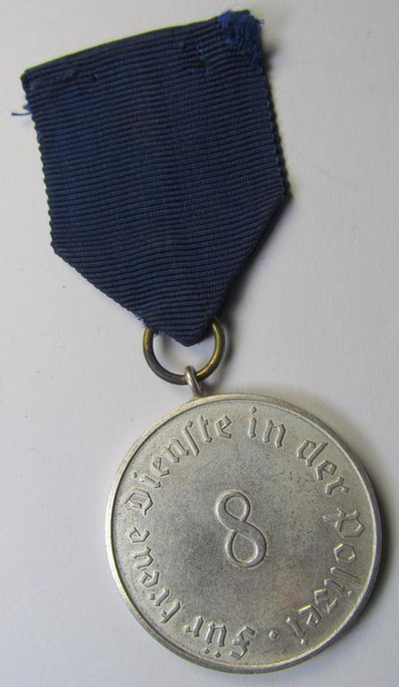 Moderately worn, bright-silver-toned, so-called: 'Polizei-Dienstauszeichnung 3. Stufe' (or: police loyal-service medal third-class) that comes mounted onto its period ribbon (ie. 'Bandabschnitt')