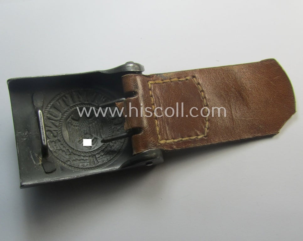 WH (Heeres) 'standard-pattern', field-grey-toned- and steel-based belt-buckle being a maker- (ie. 'H. Arld - Nuernberg'-) marked- and/or: '1941'-dated example that comes mounted onto its leather-based tab