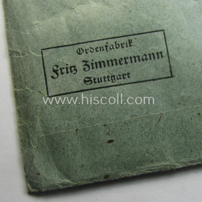 Medal-pouch entitled: 'Eisernes Kreuz 2. Klasse 1939' being a (typical) bluish-coloured example as executed in: 'Zellstoff'-based paper as was produced by the maker- (ie. 'Hersteller'): 'Ordenfabrik Fritz Zimmermann'