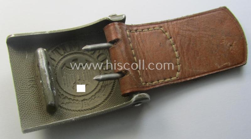 WH (Heeres) 'standard-pattern', field-grey-toned- and aluminium-based belt-buckle being a maker- (ie. 'Hermann Knoller - Pforzheim'-) marked- and/or: '1939'-dated example that comes mounted onto its leather-based tab