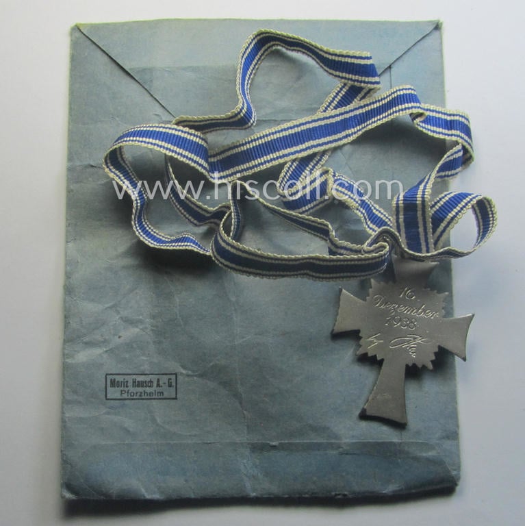 'Ehrenkreuz der deutschen Mutter - zweite Stufe' (or: silver-class mothers'-cross) that came mounted onto its long-sized ribbon and that came stored in its period pouch by the maker: 'Moriz Hausch A.-G. - Pforzheim'
