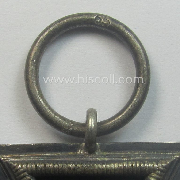 'Eisernes Kreuz 2. Kl.' (ie. Iron Cross 2nd Class) being a maker- (ie. '65'-) marked example that comes stored in its period 'Zellstoff'-based pouch by the: 'Klein & Quenzer'-company