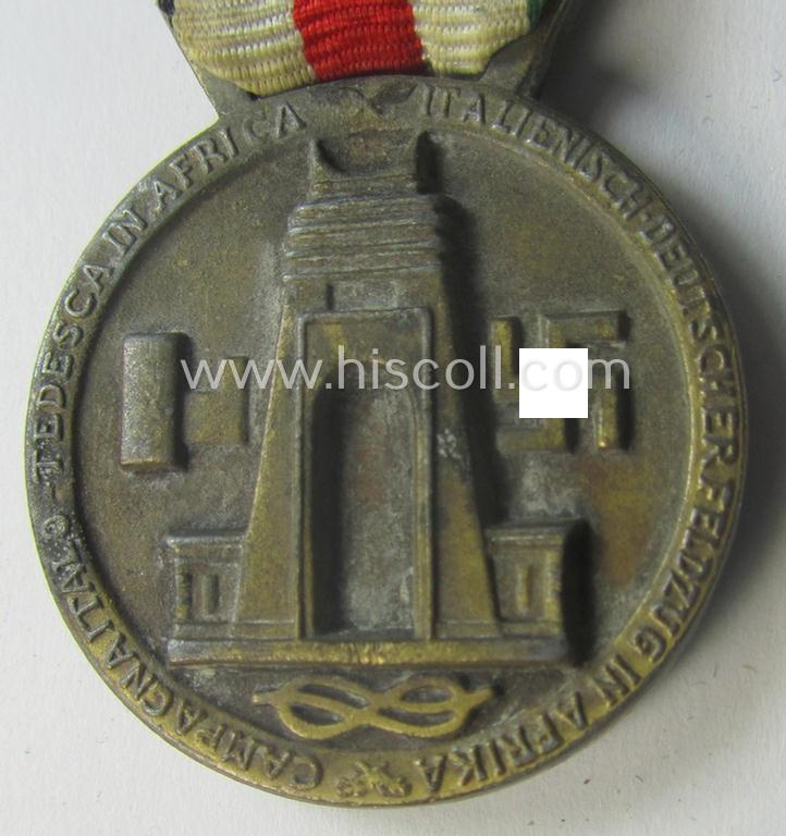 Golden-bronze-coloured (and zinc-based!) example of a: 'Deutsch-Italienische Feldzugsmedaille' (or: German-Italian campaign-medal) that comes mounted onto its (regular-sized) piece of original (and minimally faded- ie. stained!) ribbon