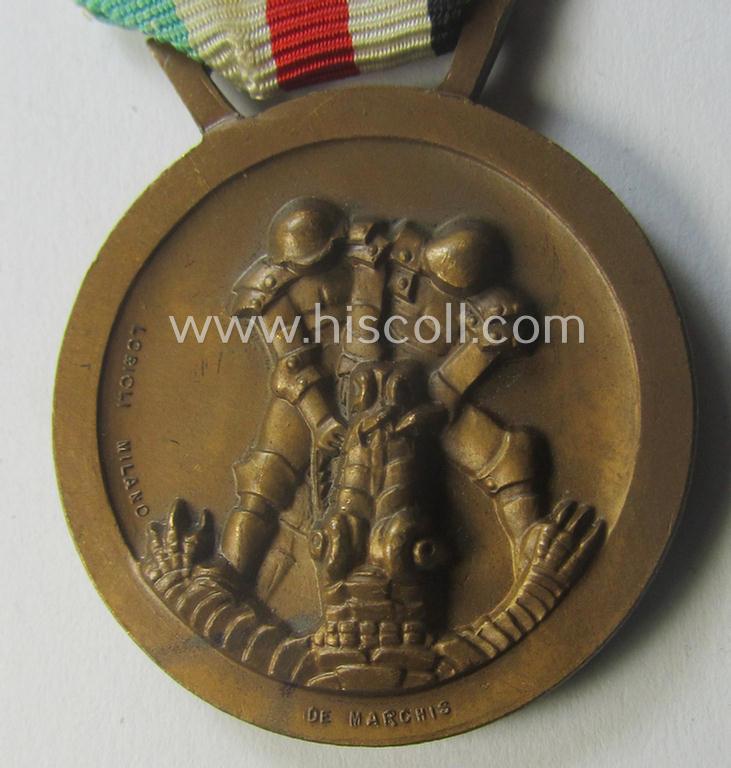 Golden-bronze-coloured- (and I deem 'Buntmetall'-based-) example of a: 'Deutsch-Italienische Feldzugsmedaille' (or: German-Italian campaign-medal) that comes mounted onto its (regular-sized) piece of original (and minimally faded- ie. stained!) r...