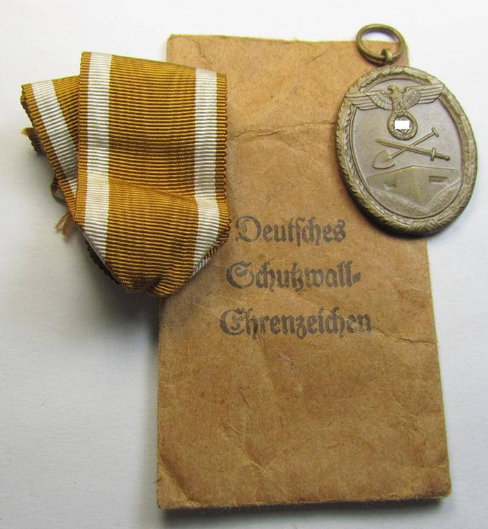 Superb medal-set: 'Deutsches Schutzwall Ehrenzeichen' (aka: 'Westwall'-medal) being a non-maker-marked- and/or: 'Buntmetall'-based specimen that comes packed in its original pouch of issue by the: 'August Menze & Sohn'-company