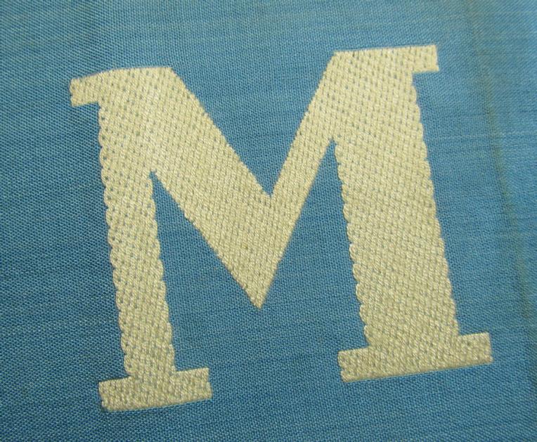 Linnen-based- and/or light-blue-coloured armband (ie. 'Armbinde') depicting an interwoven capital 'M'-character, as was presumably intended for staff-members of the German RLB (ie. 'Reichsluftschutz-Bund')