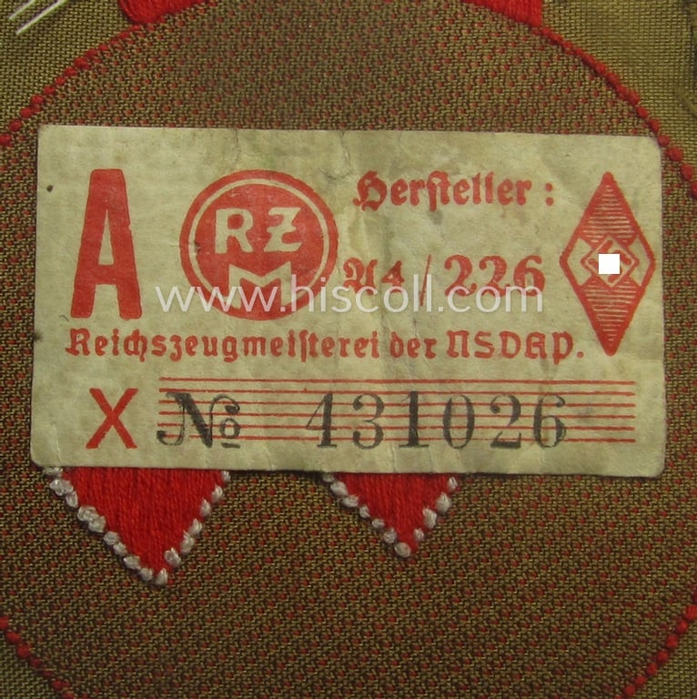Moderately used, DJ (ie. 'Deutsches Jungvolk') arm-badge as was specifically intended for usage by a member who served within the: 'Oberbann 1' (being a tunic-removed example that still shows its 'RzM'-etiket)