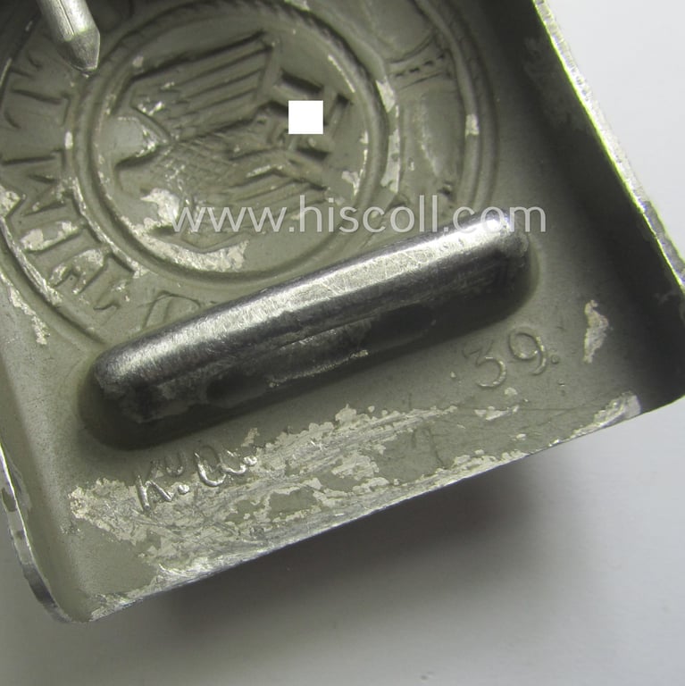 WH (Heeres) 'standard-pattern', field-grey-toned- and aluminium-based belt-buckle being a maker- (ie. 'Steinhauer & Lück'-) marked- and/or: '1939'-dated example that comes mounted onto its leather-based tab