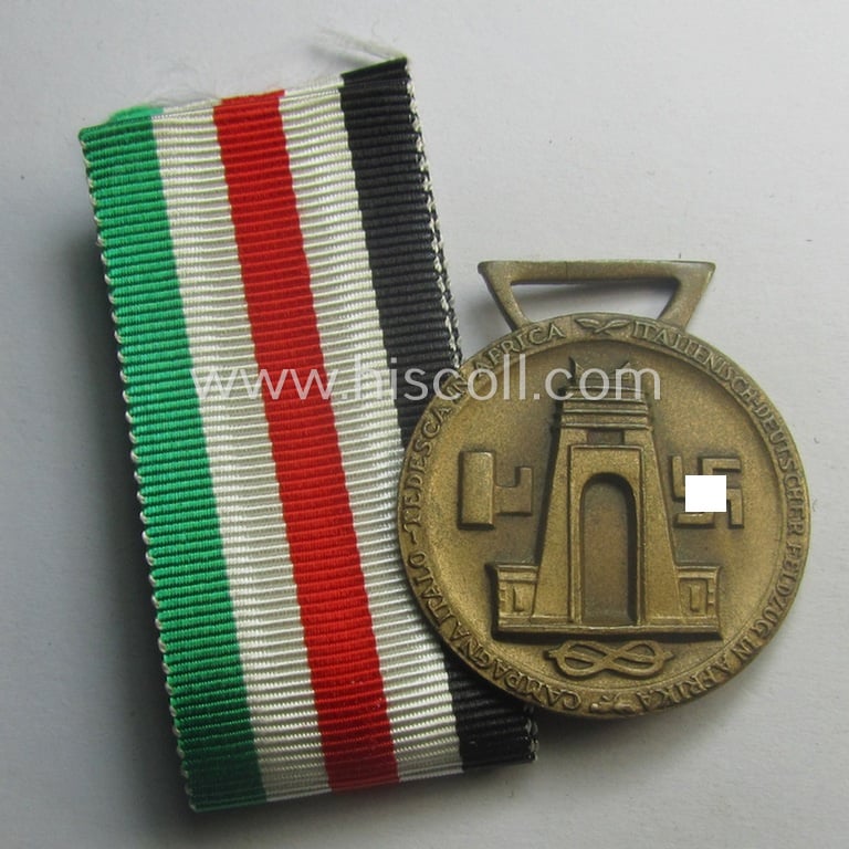 Golden-bronze-coloured (and 'Buntmetall'-based!) example of a: 'Deutsch-Italienische Feldzugsmedaille' (or: German-Italian campaign-medal) that came together with its (full length- and 'virtually mint- ie. unissued') piece of original ribbon