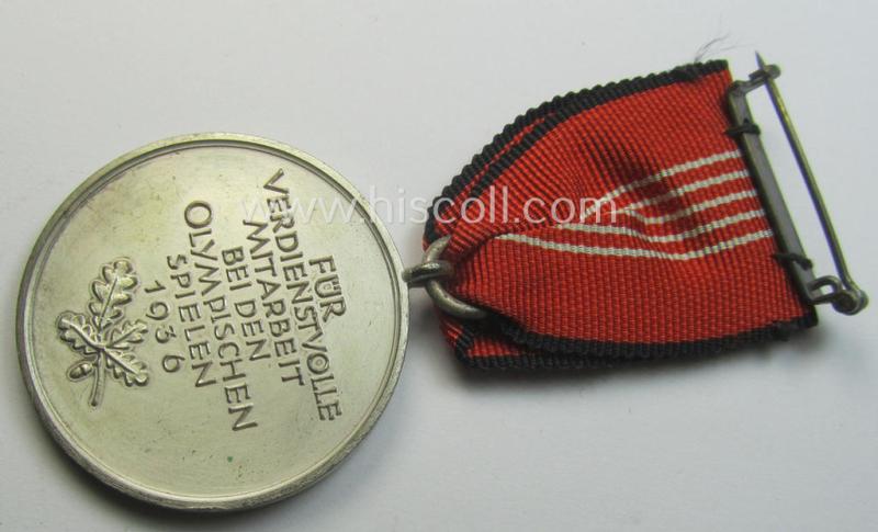'Deutsche Olympia-Erinnerungsmedaille 1936' being a non-maker-marked example that comes mounted onto its original ribbon (ie. 'Bandabschnitt') and that comes stored in its typical, beige-white-coloured etui