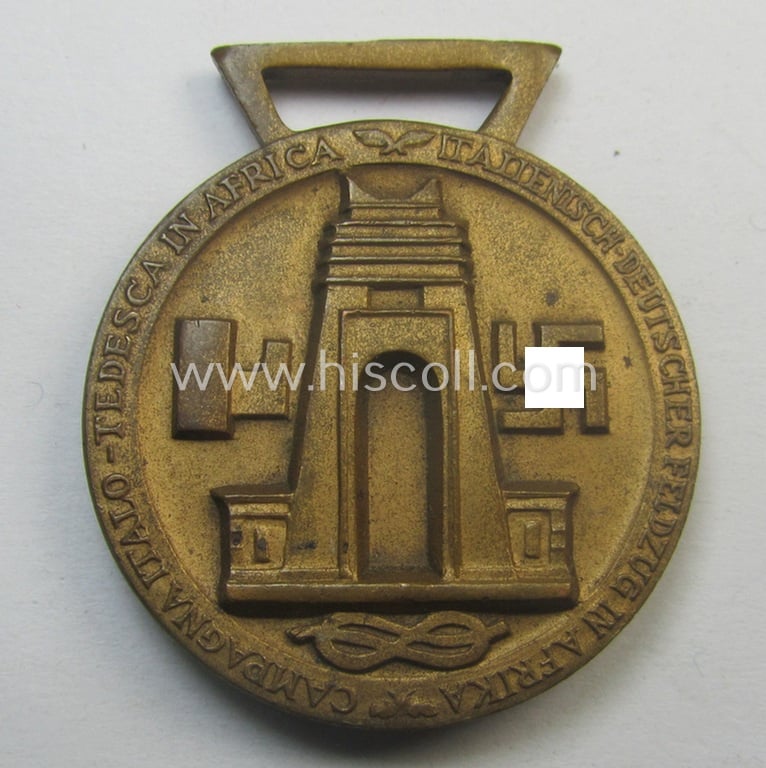 Golden-bronze-coloured (and 'Buntmetall'-based!) example of a: 'Deutsch-Italienische Feldzugsmedaille' (or: German-Italian campaign-medal) that came together with its (full length- and 'virtually mint- ie. unissued') piece of original ribbon