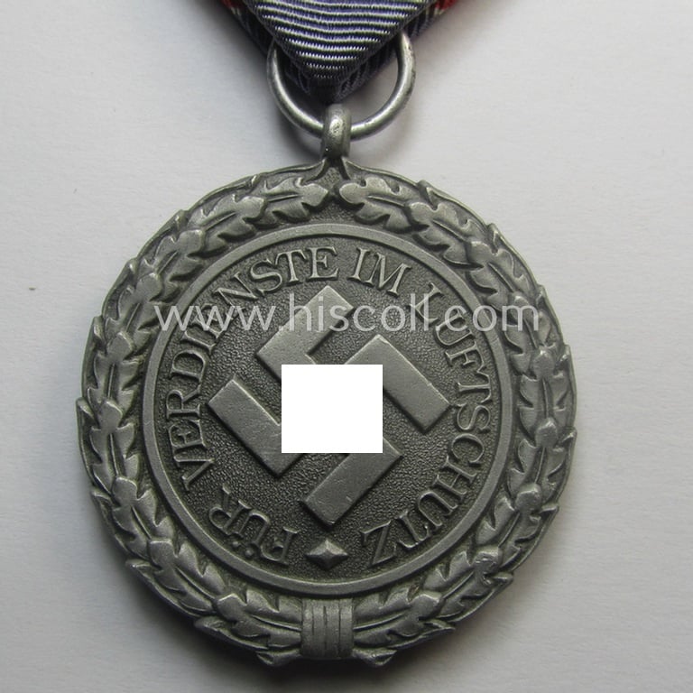 Light-weight (ie. typical aluminium-based) medal (and accompanying ribbon-bar!) as was intended for air-raid wardens 2nd. class (or: 'Luftschutz-Ehrenzeichen 2. Stufe') that comes stored in its period, dove-grey-coloured etui