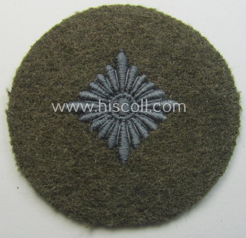 WH (Heeres) 'standard-type'- and early-pattern, tropical-style rank-insignia (ie. roundel), as executed in bluish-grey coloured linnen on a brownish-green background: 'Oberschütze'