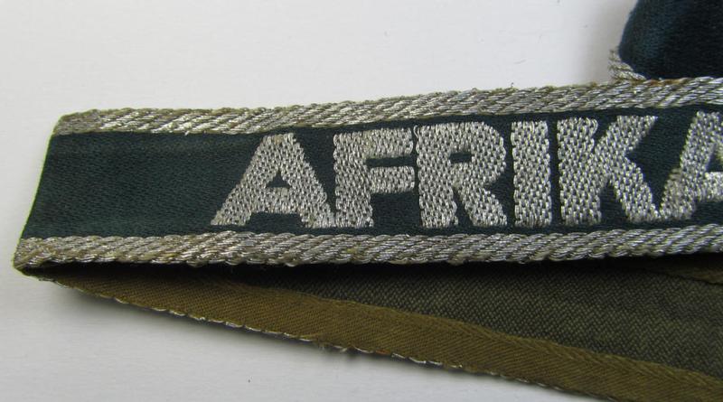 Superb, 'BeVo'-like cuff-title (ie. 'Ärmelstreifen') entitled: 'Afrikakorps' being a with certainty issued and truly worn example that comes in an overall nice- (ie. non-shortened- and most certainly once tunic-attached-), condition