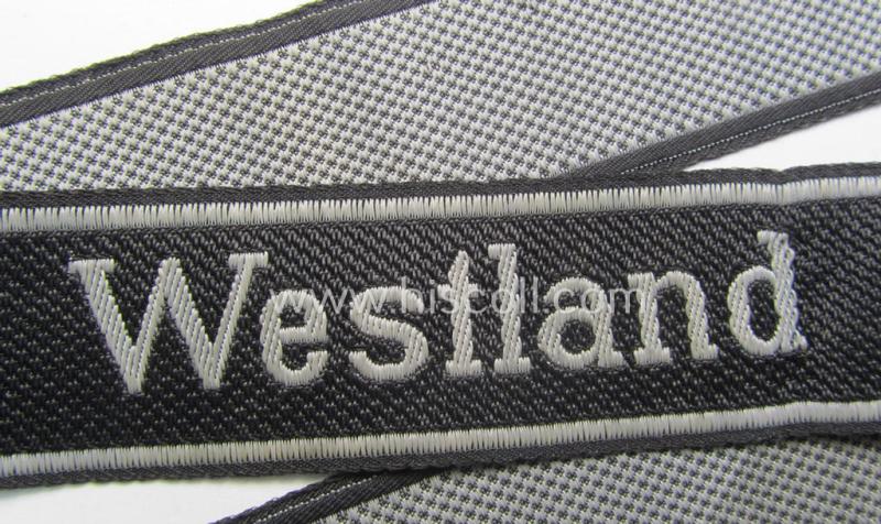 Waffen-SS, 1943/44 pattern cuff-title (ie. 'Ärmelstreifen') depicting the machine-woven Latin script text in silver-grey linnen as was intended for a member of the: 'SS-Regiment "Westland" (ie. part of the: '5. SS-Pz-Gren.-Div. "Wiking")
