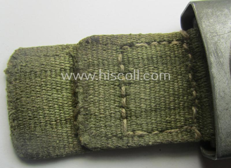 WH (Luftwaffe) 'tropical-issued' belt-buckle being a non-maker-marked, greyish-silver-coloured example that comes mounted onto its original, greenish-coloured- (and/or: 'webbing'-based-) tab