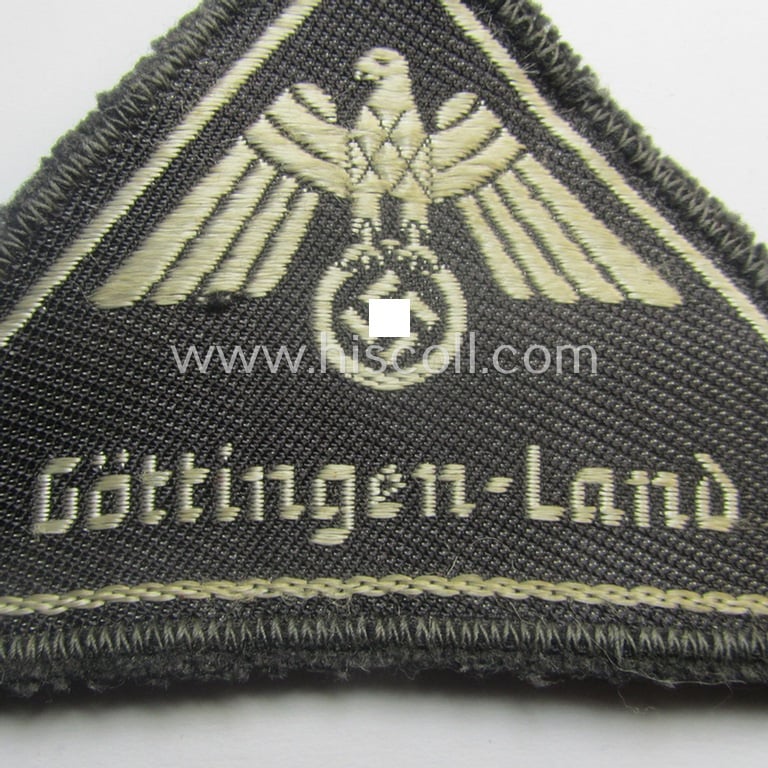 German Red Cross (ie. 'Deutsches Rotes Kreuz' or 'DRK') related, EM- (ie. NCO-) type, greyish-coloured- and/or (typically) triangular-shaped arm-eagle as executed in the neat 'BeVo'-weave pattern entitled: 'Göttingen-Land'