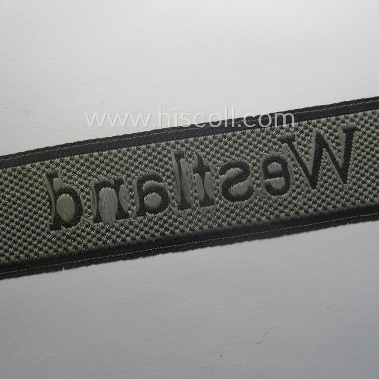 Waffen-SS, 1943/44 pattern cuff-title (ie. 'Ärmelstreifen') depicting the machine-woven Latin script text in silver-grey linnen as was intended for a member of the: 'SS-Regiment': "Westland" (ie. part of the: '5. SS-Pz-Gren.-Div. "Wiking")