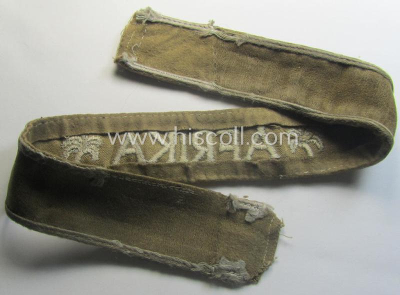 WH cuff-title (ie. 'Ärmelstreifen') entitled: 'Afrika' (being an example that bears a printed 'RbN.'-numeral ('RBN.0/0250/2340') and that comes in an issued, clearly worn- and/or most certainly once tunic-attached, condition)
