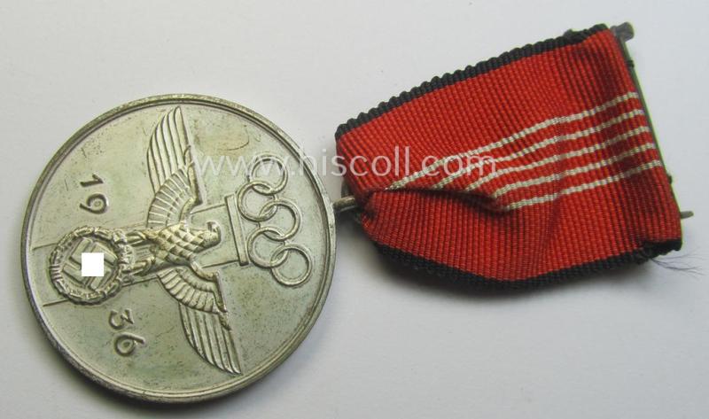 'Deutsche Olympia-Erinnerungsmedaille 1936' being a non-maker-marked example that comes mounted onto its original ribbon (ie. 'Bandabschnitt') and that comes stored in its typical, beige-white-coloured etui