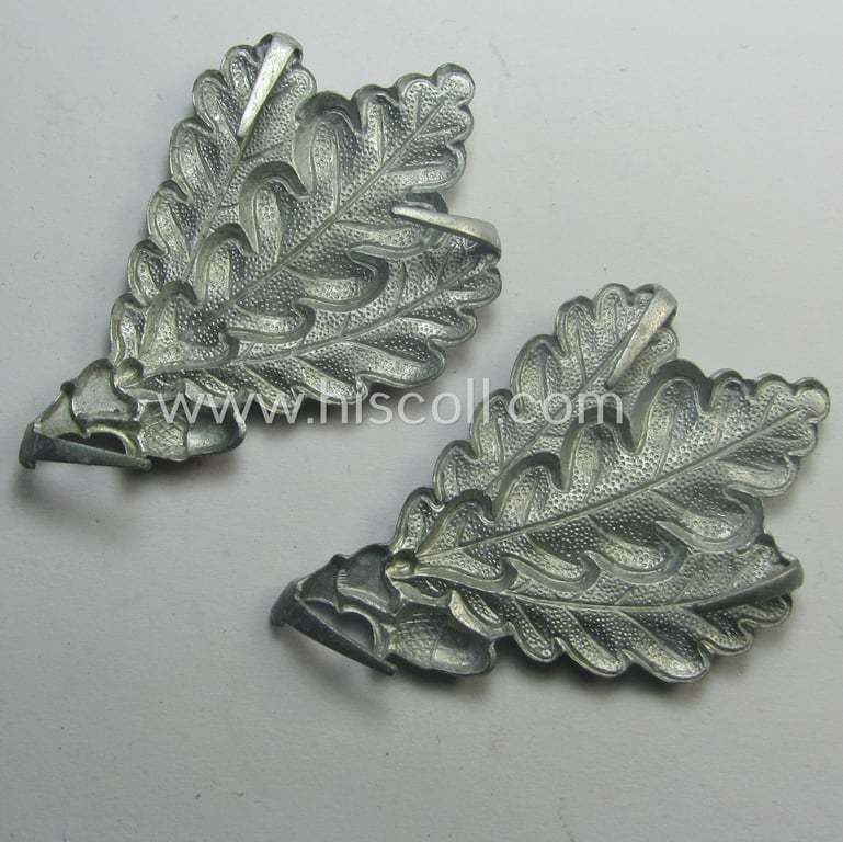 WH (Heeres) silver-coloured so-called: 'M43'-pattern cap-badge (ie. 'Mützenabzeichen') depicting three: 'Eichenlaub'-branches as was used by the various 'Jäger'-related, divisional staff-members